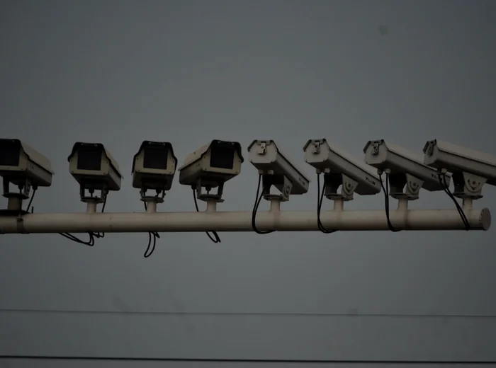 Fila di telecamere di videosorveglianza allineate su una barra